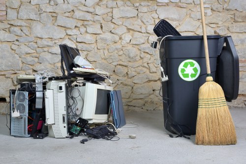 Workers sorting green waste and timber for recycling in a Fulham property